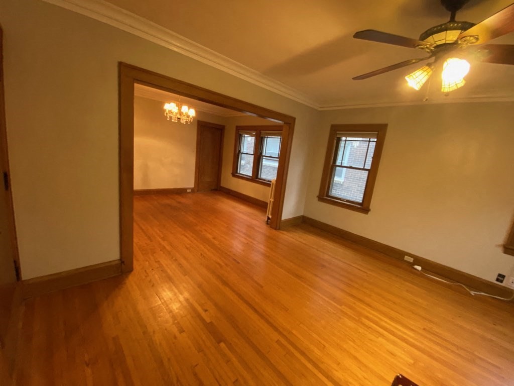 a living room with wooden floors and a ceiling fan