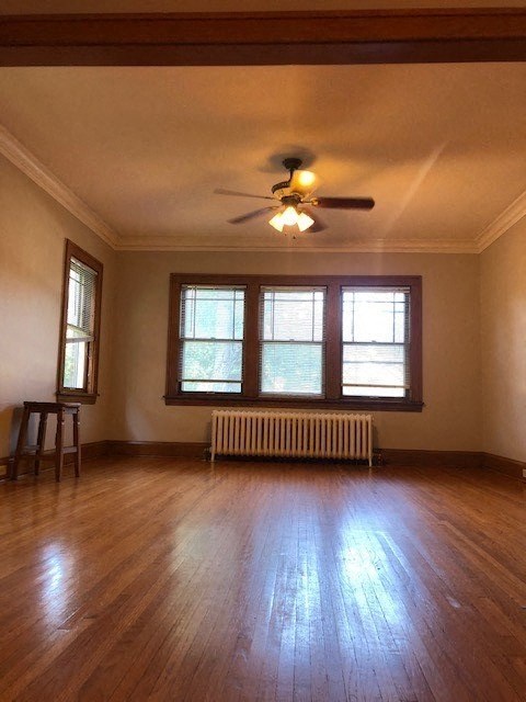 an empty living room with a ceiling fan and a window
