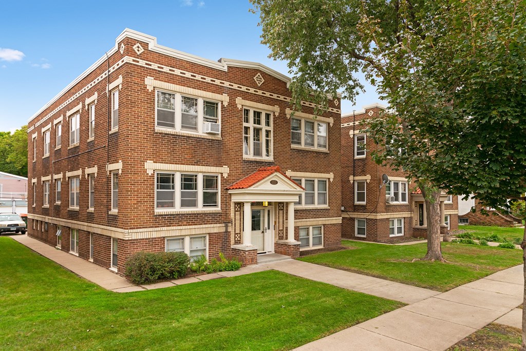 a red brick building with a sidewalk in front of it