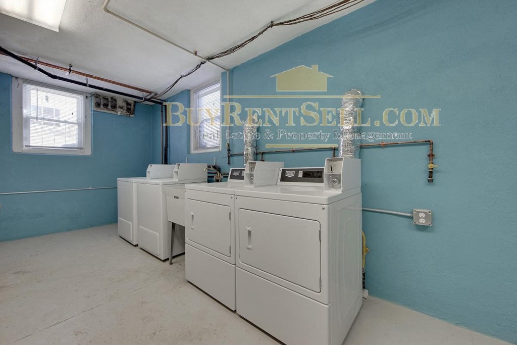 a group of washers and dryers in a laundry room