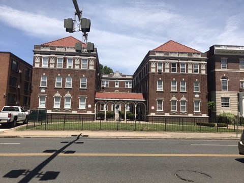 A large red brick building with a white trim and a red roof.