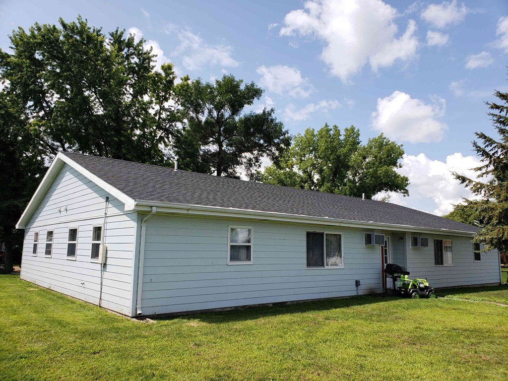 a white house with a lawn and trees