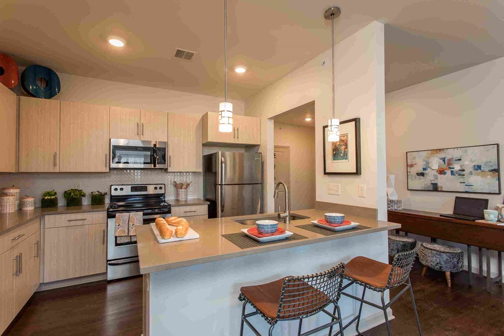 a kitchen with a center island with three stools