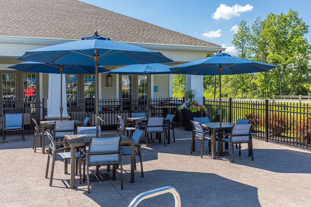 a patio with tables and chairs and umbrellas