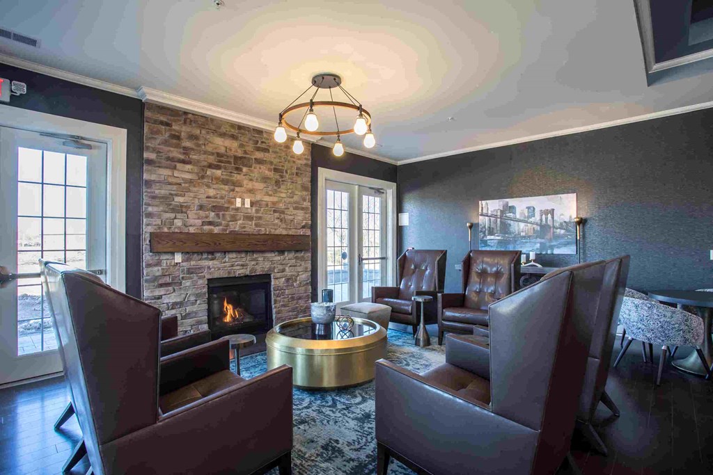 a living room with leather chairs and a fireplace