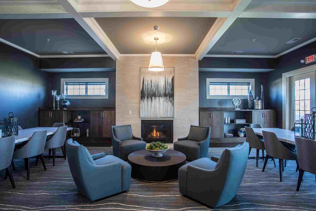 a large lobby with chairs and a table and a fireplace