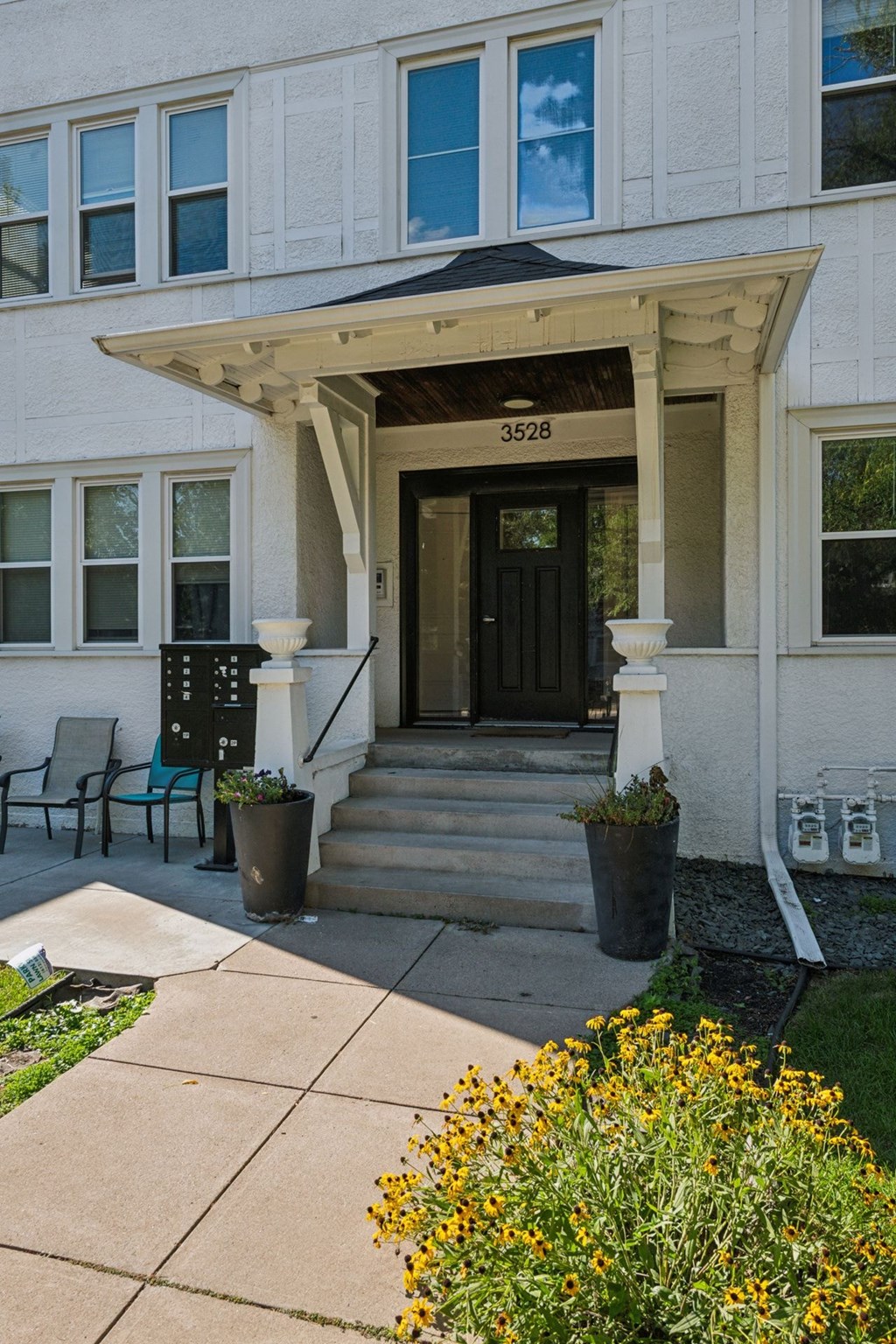 A white building with a black door and a number 3528 on the top.