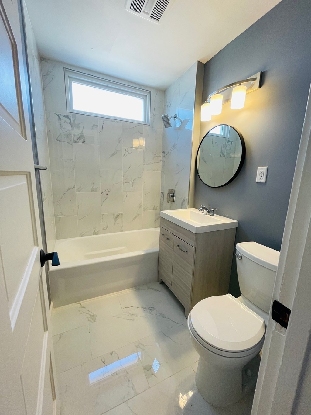 A bathroom with a toilet, sink, and tub.