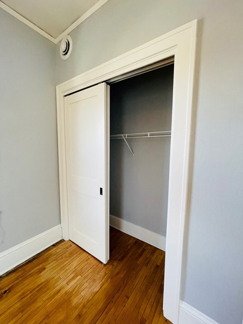 an empty bedroom with a closet with a door open