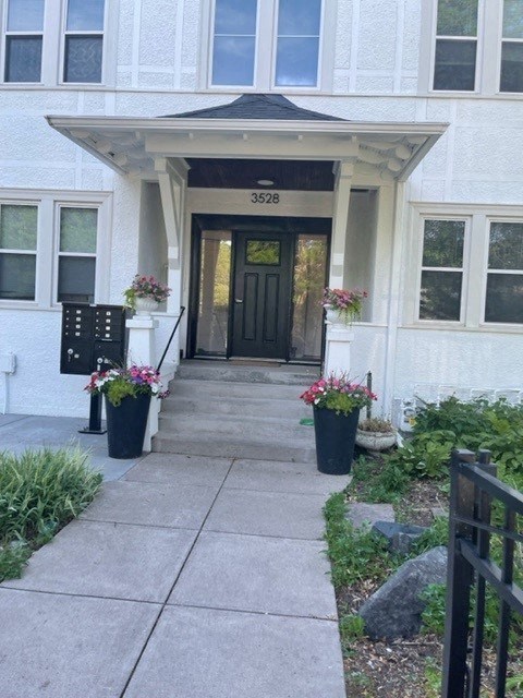 the front door of a house with flowers on the steps