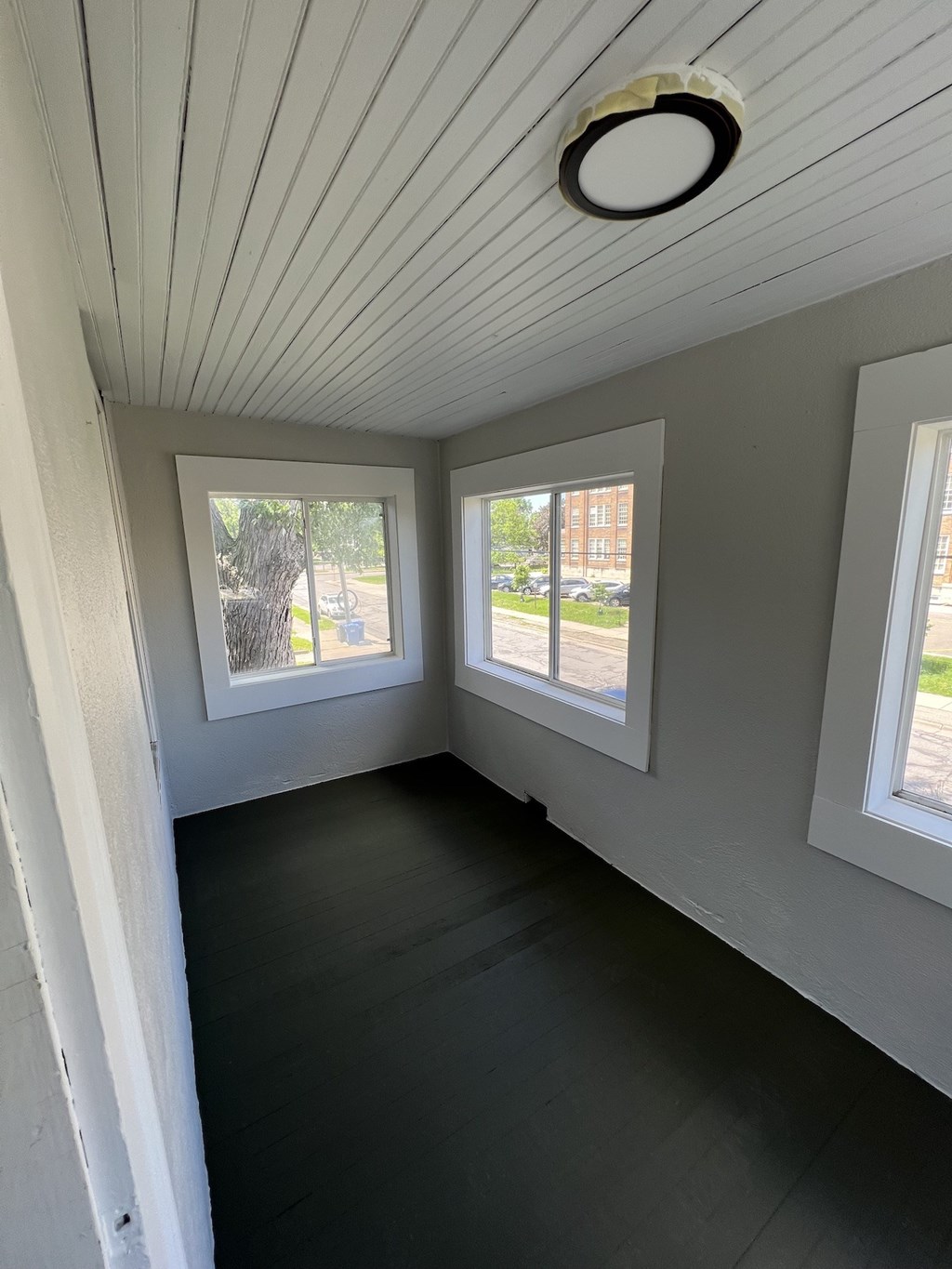 the inside of a tiny house with a wood floor and windows