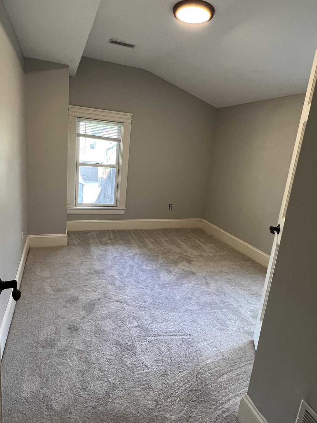 an empty room with carpet and a window