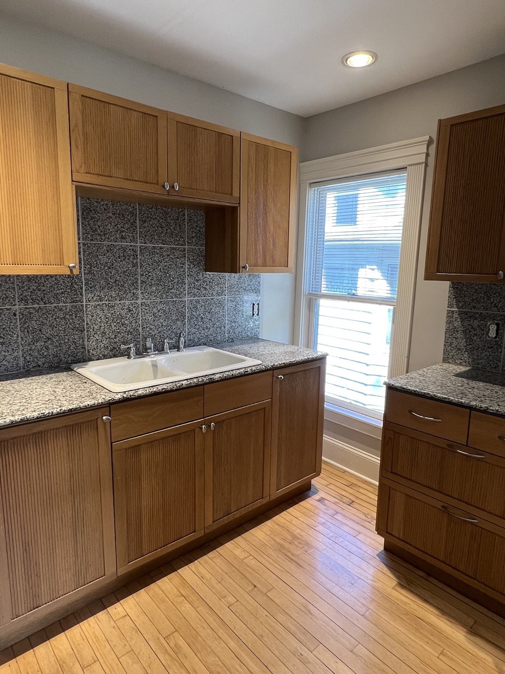 a kitchen with wooden cabinets and a sink and a window