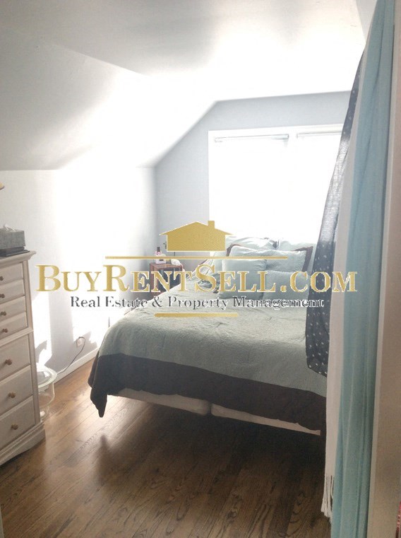 A bedroom with a bed, nightstand, and dresser.