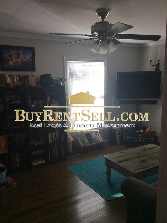 A living room with a Buy Rent Sell advertisement.