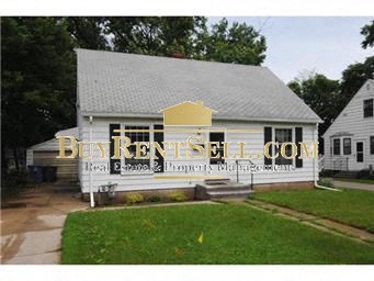 A white house with a sign that says BuyKentSell.com in front of it.