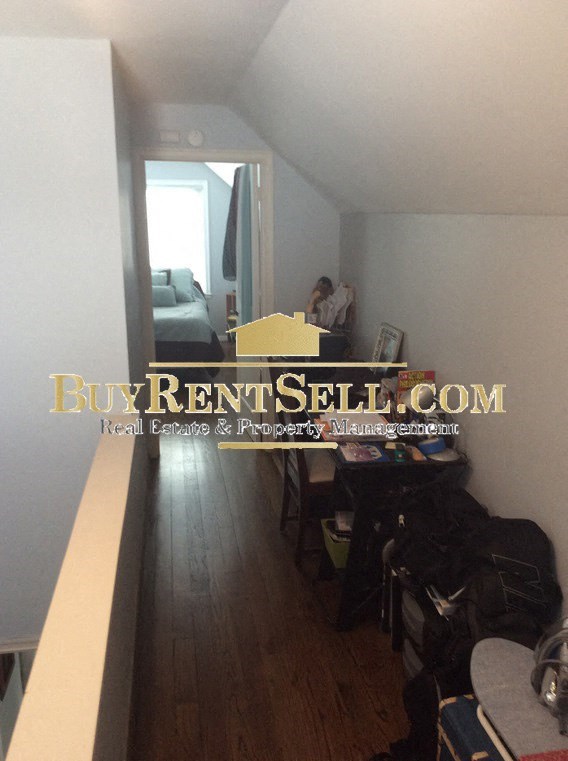 A hallway with a BuyRentSell.com sign on the wall.