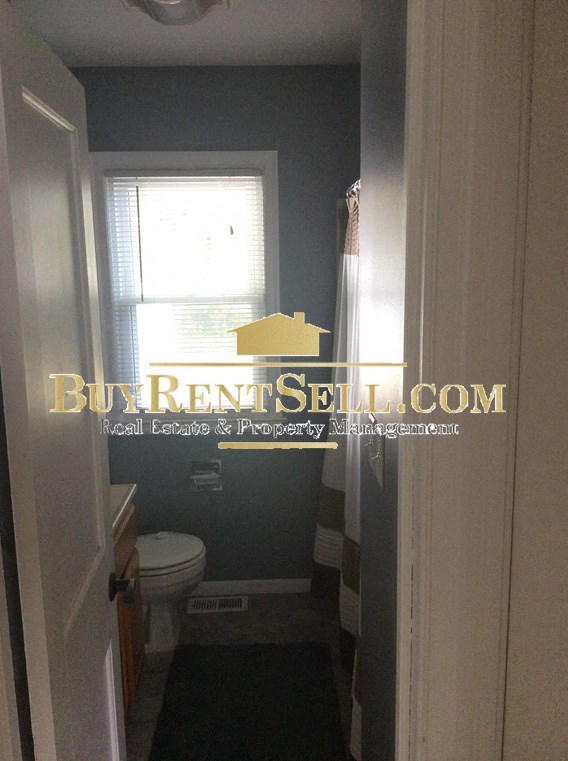 A bathroom with BuyRentSell.com logo on the window.