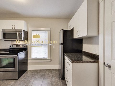 a kitchen with stainless steel appliances and white cabinets