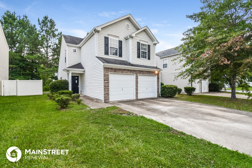 a white house with a garage and a driveway