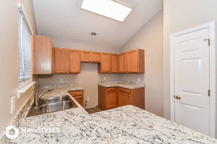 a kitchen with granite counter tops and wooden cabinets