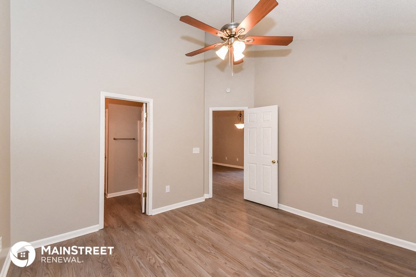 the living room of an empty house with a ceiling fan