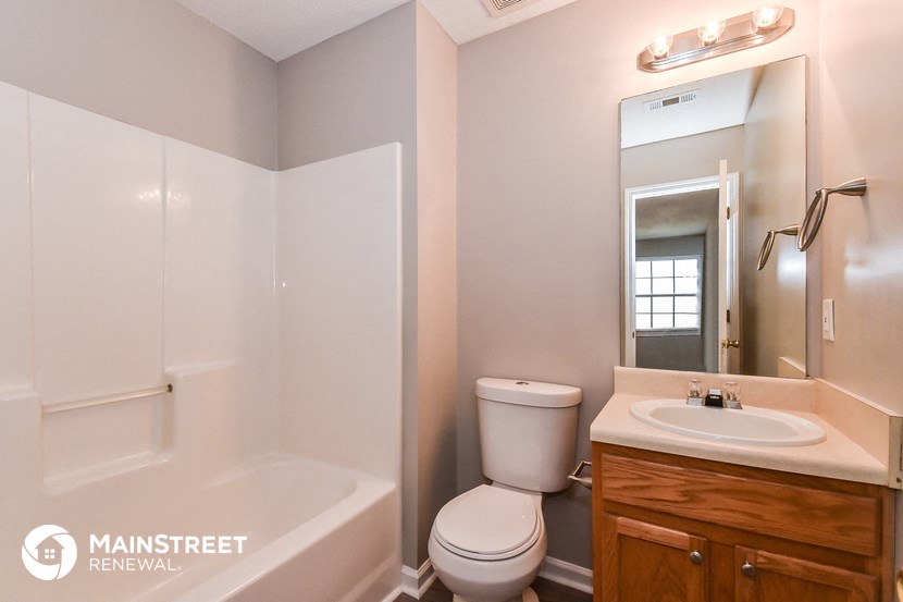 a bathroom with a toilet and a sink and a bath tub