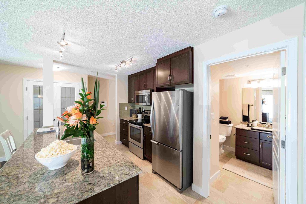 a kitchen with stainless steel appliances and a counter with flowers