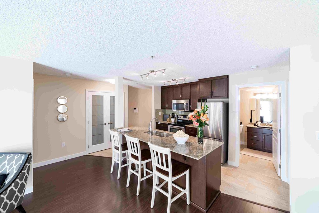 a kitchen with a island with chairs and a counter