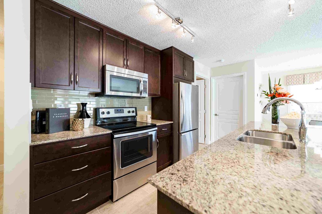 a kitchen with stainless steel appliances and granite counter tops