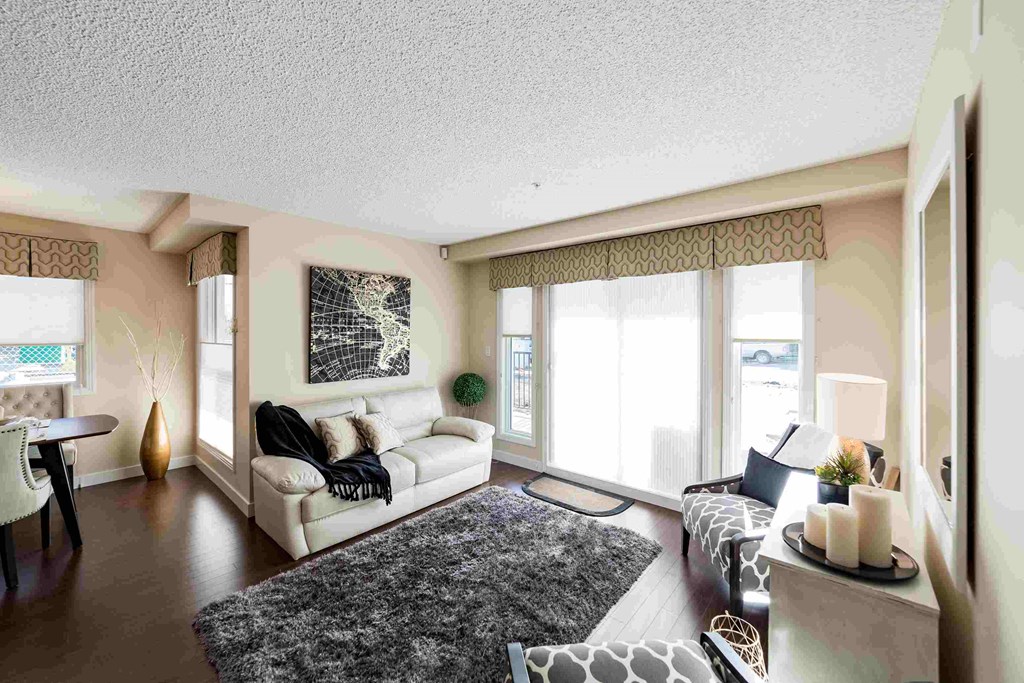 a living room with a white couch and chair and a rug