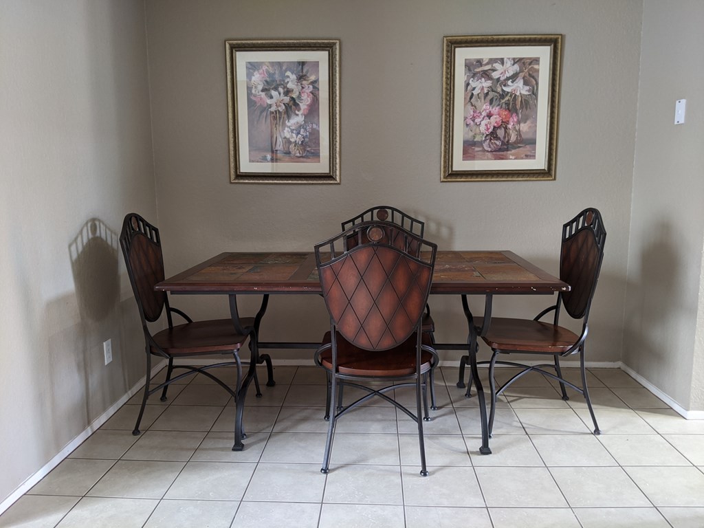 A dining room with a table and chairs.