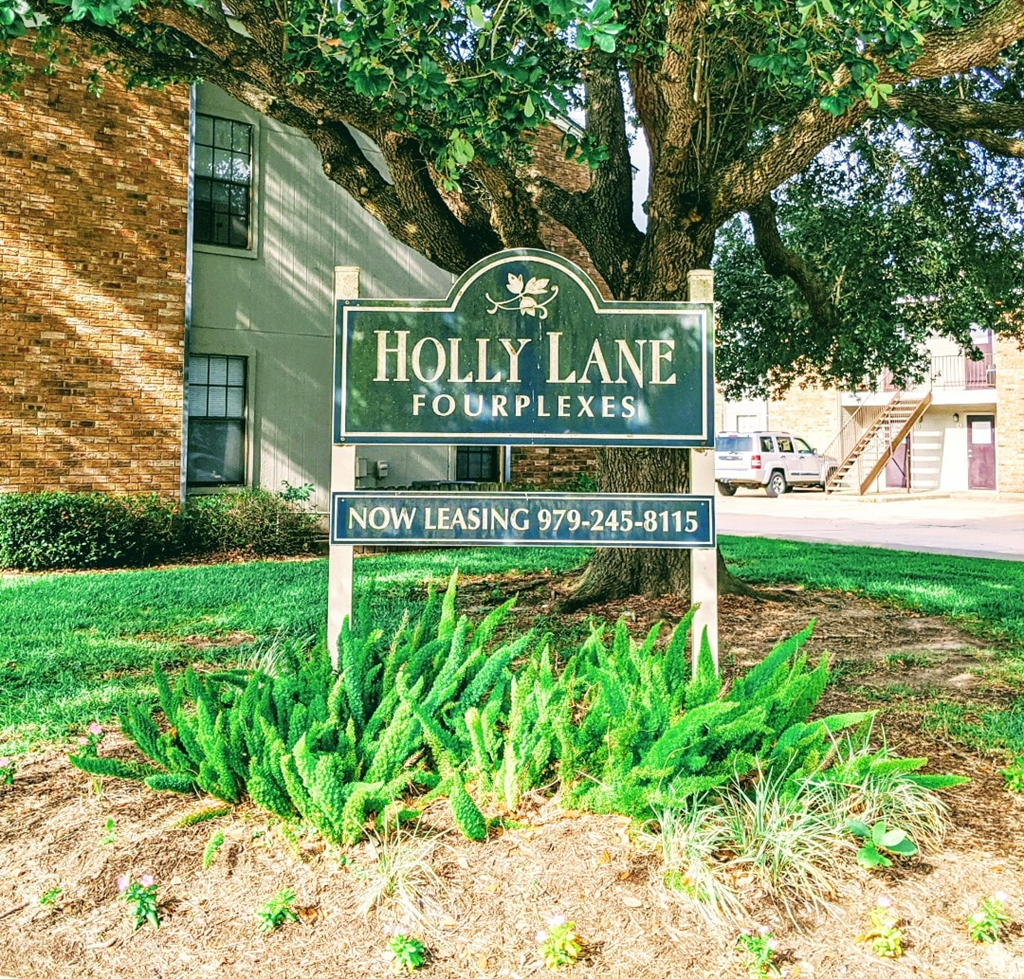 A sign for Holly Lane Fourplexes with a phone number for leasing.