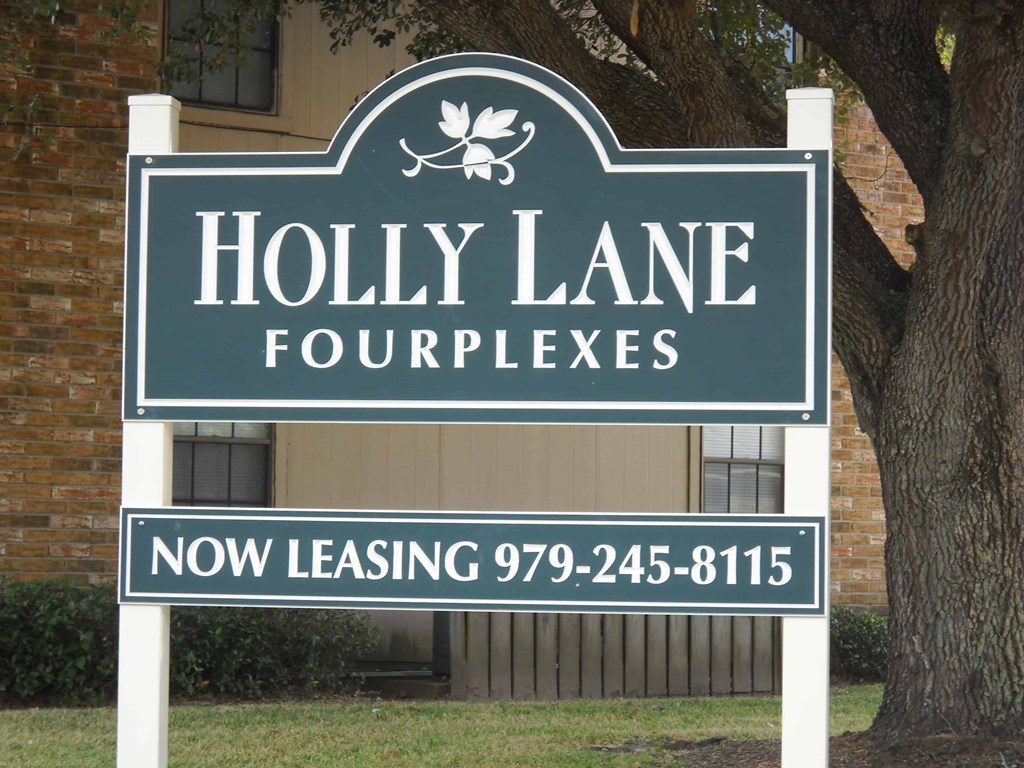 A sign for Holly Lane Fourplexes with a phone number for leasing.