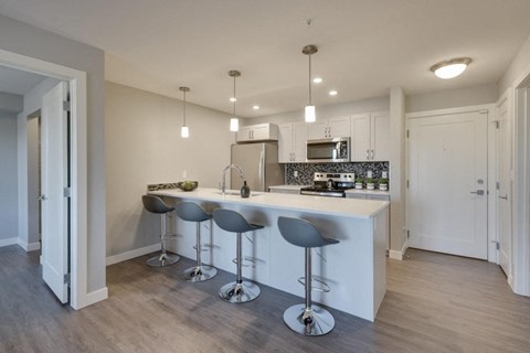 a kitchen with a bar and stools