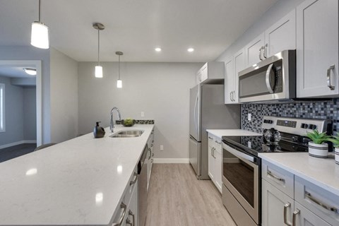 a kitchen with white cabinets and stainless steel appliances