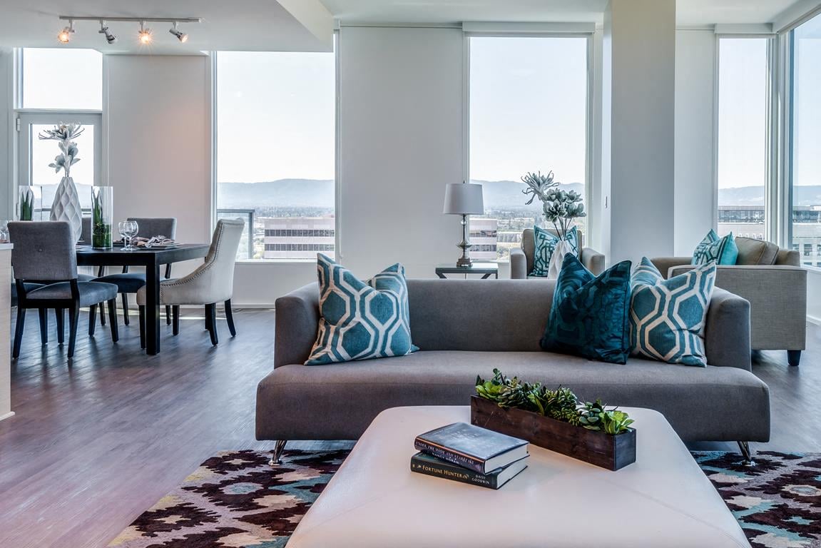 A living room with a grey couch and a white coffee table.
