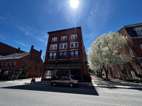 A car is parked on the side of a street in front of a building.