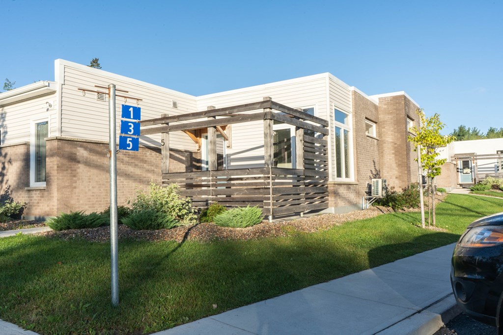 the exterior of a building with a porch and a street sign