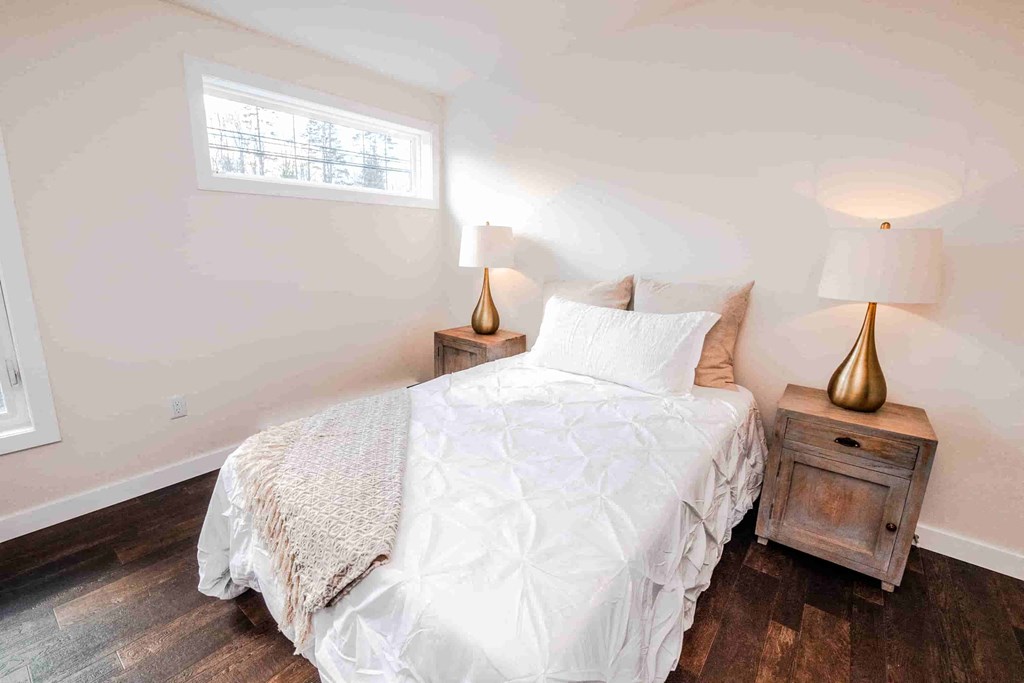 a bedroom with a white bed and a window