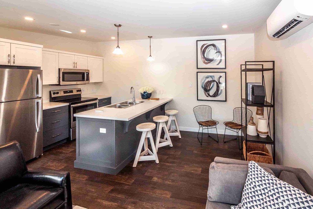 an open kitchen and living room with an island and stools