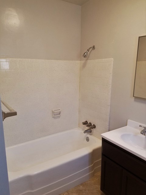 an empty bathroom with a tub and a sink