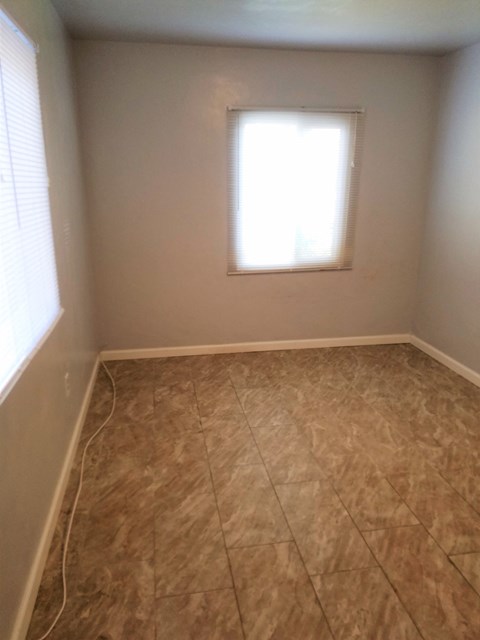 an empty room with tiled floors and a window