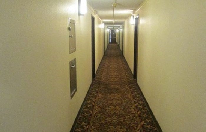 a long hallway with a carpet in a hotel room