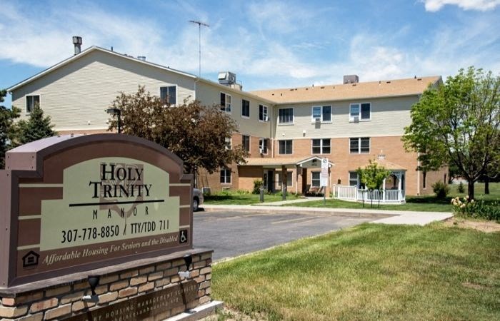 a building with a sign for how trinity apartments