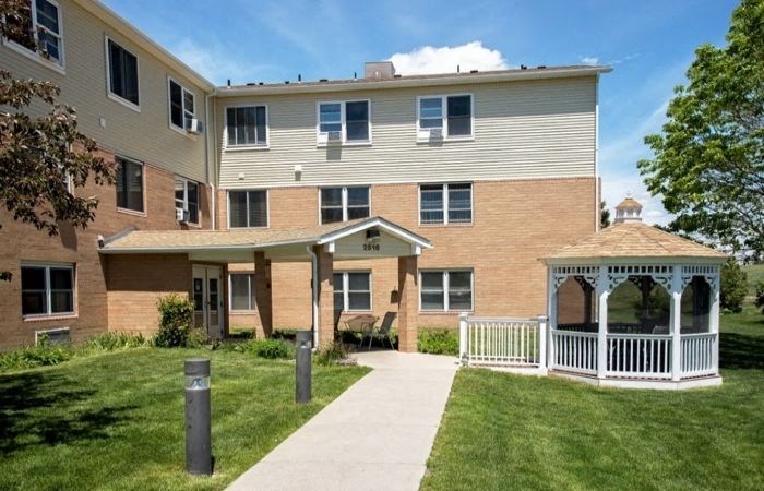 an apartment building with a gazebo and a sidewalk