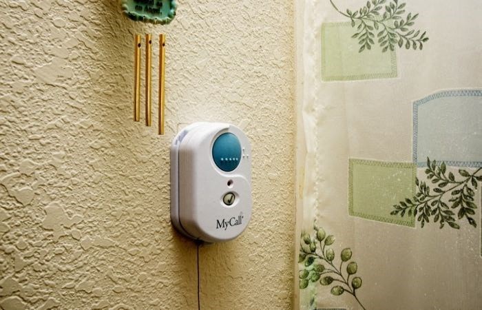a thermostat on a wall with three chopsticks