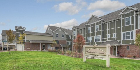 an exterior view of an apartment building with a sign in front of it