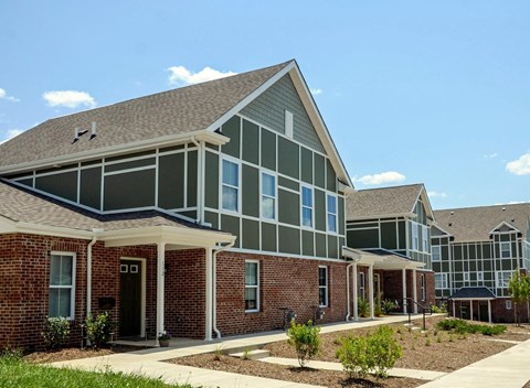 the exterior of an apartment building with brick and green walls