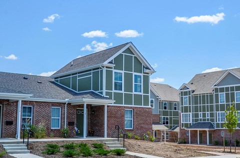 a row of brick and green houses on a sunny day